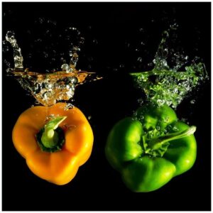 Wallario Möbelfolie Bunte Küche Paprika in orange und grün im Wasser