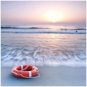 Wallario Möbelfolie Rettungsring am Strand bei Sonnenuntergang