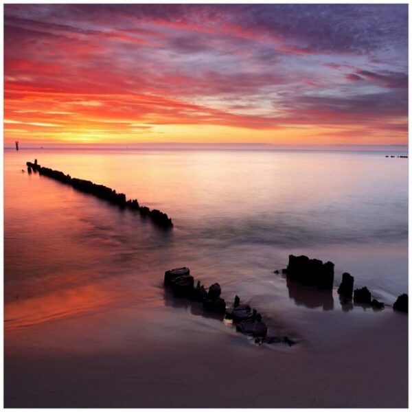 Wallario Möbelfolie Sandstrand im Sonnenuntergang - Roter Himmel