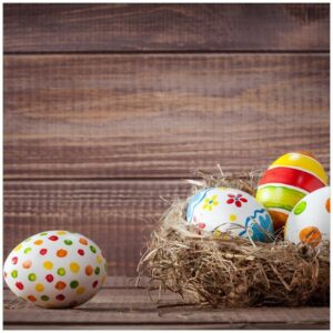 Wallario Möbelfolie Bunte bemalte Eier an Ostern im Vorgelnest vor hölzerner Wand